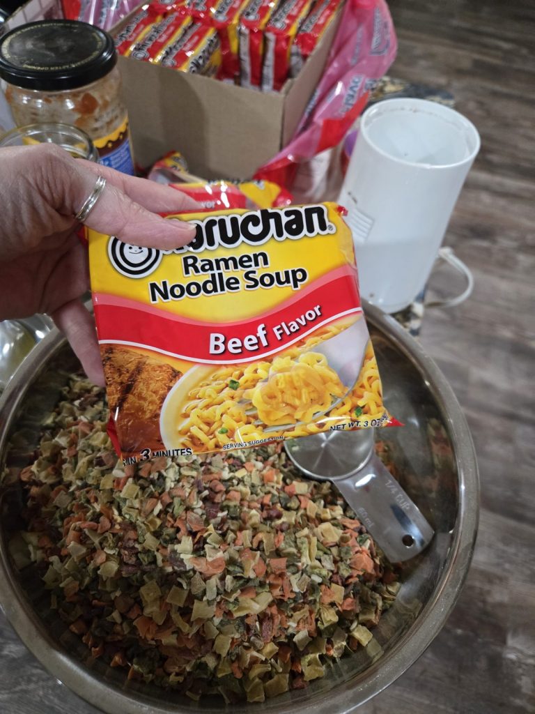 Adding a package of beef ramen noodles to the soup mix