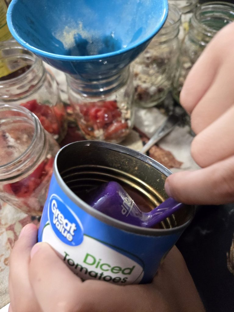 Adding canned diced tomatoes to jars of beans
