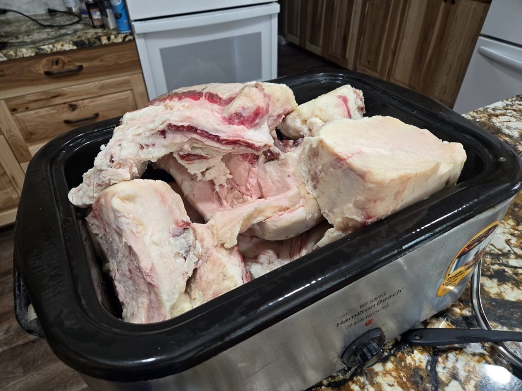 Chunks of beef fat in an electric roaster before rendering