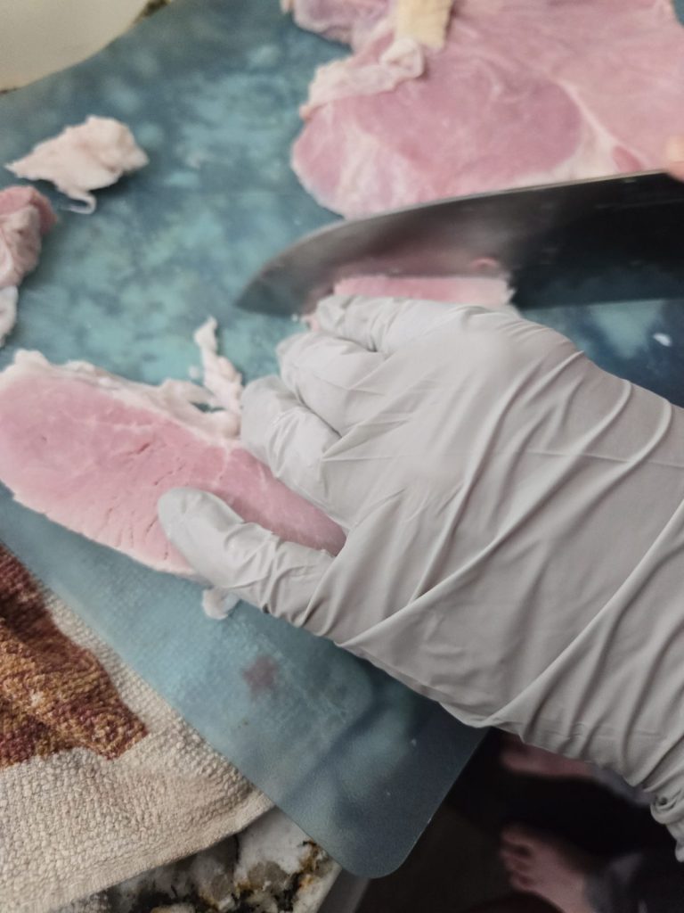 Cubing ham on a cutting board